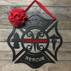 a fire department sign hanging on the side of a wooden wall with a red ribbon