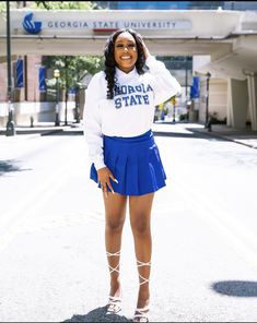 a woman standing in the middle of a street wearing a skirt and white shirt with florida state letters on it