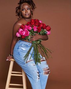 a woman is holding flowers and posing on a ladder