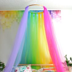 a rainbow colored canopy bed in a bedroom