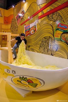 a man standing in front of a bowl of noodles