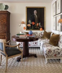 a living room filled with furniture and paintings on the wall