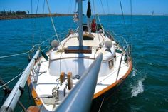 a sailboat sailing in the ocean on a sunny day