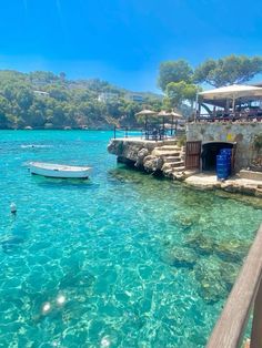 the water is crystal blue and clear, with boats in the shallow lagoons below