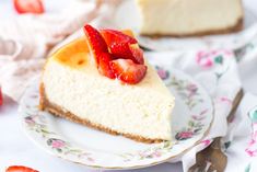 a slice of cheesecake with strawberries on top is sitting on a floral plate