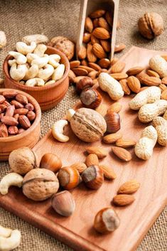 nuts are scattered on a wooden cutting board