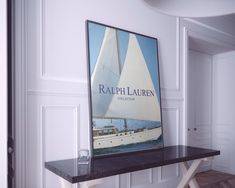 a sailboat poster hangs on the wall above a table