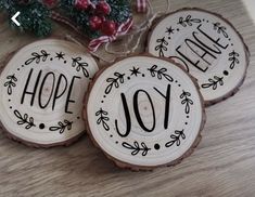 three wood slices with the words hope and joy painted on them sitting on a table