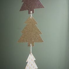 a paper christmas tree hanging from a string