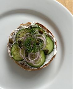 an open face sandwich with cucumbers, onions and dill on rye bread