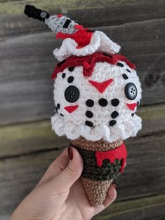 a crocheted ice cream cone with a clown face on it