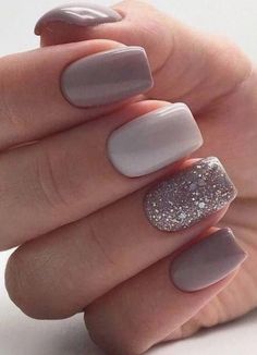 a woman's hand with grey and silver manicures on it, holding onto her nails