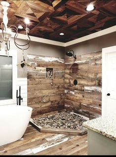 a bathroom with wood paneling and a tub in the corner, lights on above it