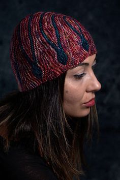 a woman with long hair wearing a red and blue knitted hat on her head