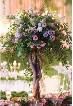 an arrangement of flowers and greenery on a table