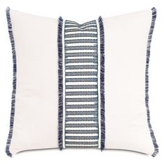 a blue and white pillow with fringes on the front, two side by side