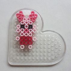 a heart shaped beaded object with pink and black beads in the shape of a bear