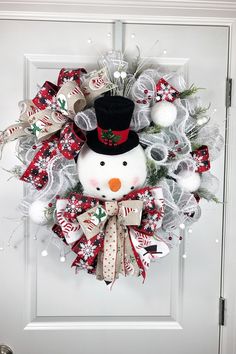 a christmas wreath with a snowman wearing a top hat and bow tie on the front door