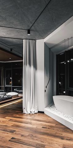 a bathroom with a large tub and wooden floors