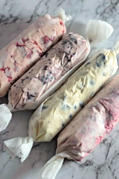 three different types of ice cream sitting on top of a marble counter next to each other