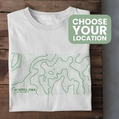 Celebrate your favourite outdoors location with a custom Contour Map T-Shirt! Perfect for any mountain lover, just let us know the location in the personalisation box. We will send you a proof of the design within 1-2 days so you can approve before print! The contour map is designed using online mapping data to make a unique, minimalistic visual that's perfect for an outdoors lover. This Unisex t-shirt is Vegan approved, Gots accredited and Fairwear Foundation certified which makes it a highly eco-friendly product. *Packaging This product is packaged in 100% plastic-free packaging that is compostable and degradable. *Delivery Our products are made to order and aim to have a 7 working day turn around or less for UK orders (Production and Royal Mail First Class Delivery)  Custom orders can t Sustainable Tshirt Design, Map Shirt Design, Contemporary Tshirt Design, Map Tshirt Design, Outdoor T Shirt Design, T Shirt Design Minimalist, Nature Tshirt Design, Outdoor Tshirt Design, Hiking Shirt Design