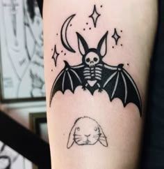 a bat with a skull on it is sitting next to a rabbit that has its wings open