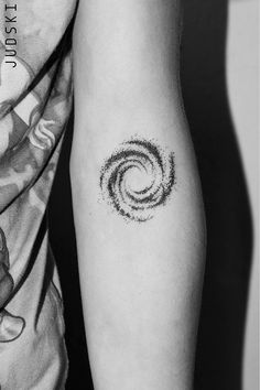 a black and white photo of a person's arm with a tattoo on it