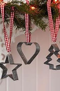 three ornaments hanging from a christmas tree in the shape of heart, star and arrow