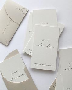 the wedding stationery is laid out on top of each other, including envelopes