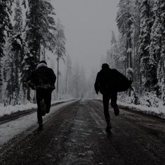 two people walking down a snow covered road