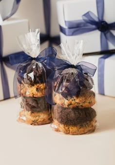 two cookies wrapped in cellophane and tied with blue ribbon are sitting next to each other