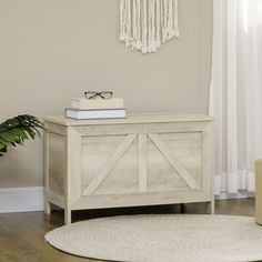 a white table with some books on top of it next to a potted plant