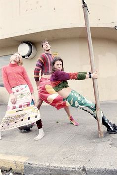 three people standing on the street with one holding a pole