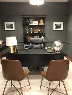 two brown chairs sitting in front of a black desk