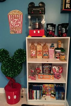 a book shelf with various items on it and a mickey mouse chair next to it