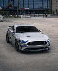 a silver sports car parked in an empty parking lot