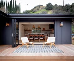 two chairs sitting on top of a wooden deck next to a table and chair set