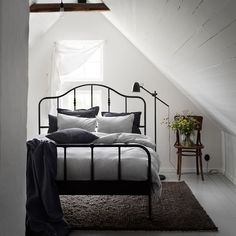 a bed sitting under a window in a bedroom