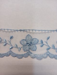 a white and blue lace with flowers on it