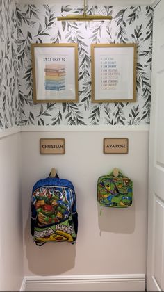 two backpacks are hanging on the wall next to each other in front of framed pictures