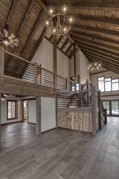 an empty living room with wood floors and beams