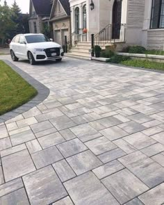 a white car is parked in front of a house with stone walkways and steps