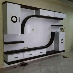 a white and black entertainment center in a room with tile flooring on the ground