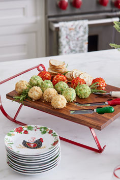 a platter with broccoli, tomatoes and other food on it next to plates