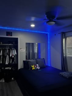 a room with a bed, closet and blue lights on the ceiling is lit up