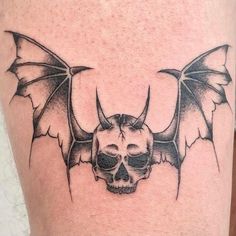 a skull and bat tattoo on the leg