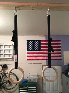 two hoop rings hanging from the ceiling in front of an american flag and a bicycle