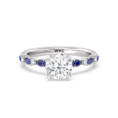 a diamond and blue sapphire engagement ring with the word wwc on it's side