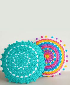 three crocheted placemats with colorful circles on the top and one in the middle