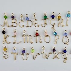 the letters and numbers are made out of gold wire with colored glass beads on them